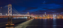 Illuminated Bay Bridge At Night And The San Francisco Skyline