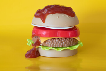 plastic Hamburger handmade with plasticine. Fast food. Isolated on yellow background . toy burger. plastic hamburger