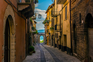 A view down a side street of the medieval city of Todi, Umbria, Italy towards the surrounding countryside in summer