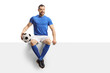 © Ljupco Smokovski - Footballer in a blue jersey with a soccer ball sitting on a blank panel and smiling