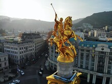 Beautiful Aerial Drone Photography. Country Georgia From Above. Capital Tbilisi. Liberty Square And Close Up Portrait Of  Saint George Golden Monument.