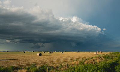 bales of hay and storm clouds