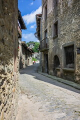 Poster - On the atmospheric paved street and Rustic house in the medieval village of Rupit in the mountainous part Catalonia. Spain.