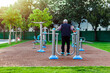 © srphotos - Old man doing leg workout with workout equipment in public park day time