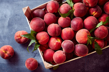 Wooden crate with fresh sweet peaches.