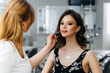 © Andrii - In a beautiful, modern beauty salon, a professional makeup stylist makes makeup for a young girl. Beauty, and fashion