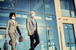 © Drazen - Business colleagues with protective face masks leaving office building.