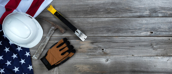 Wall Mural - Waving US flag with construction tools on weathered wooden background for Labor Day holiday