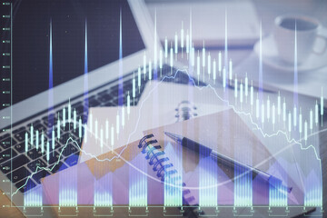 Double exposure of financial chart drawing and desktop with coffee and items on table background. Concept of forex market trading