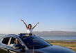© PK Studio - Asian woman in car with raised hands driving on sunset