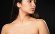 © Fernanda - Hispanic woman portrait in studio with black background - Young woman taking care of her natural skin - Beauty portrait, woman looking down unsure of herself