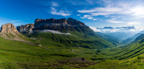 Wall Mural - Panorama of the Piz Boe mountain range at sunny foggy morning. View from Pordoi pass. Dolomites mountains, Italy, Europe.