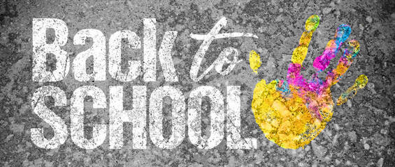 Back to school graphic banner with text written over  Concrete texture on sidewalk or driveway  with paint handprint