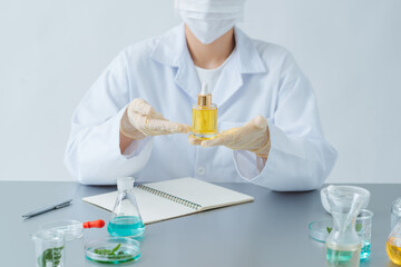 Wall Mural - female dermatologist holding bottle of skin care product at table, closeup