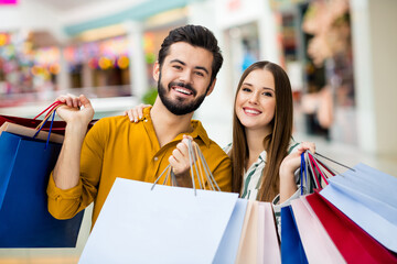 Canvas Print - Portrait of his he her she nice attractive glad cheerful cheery couple having fun spending holiday carrying new things clothes clothing wear garment trade brandy bargain indoors