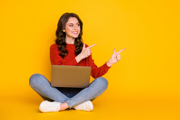 Portrait of her she nice attractive cheerful cheery wavy-haired girl sitting using laptop showing idea copy space advert isolated on bright vivid shine vibrant yellow color background