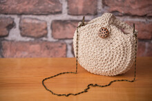 Round Beige Handbag Made Of Polyester Yarn. Handmade Crochet Purse. Product Photo. Copy Space.