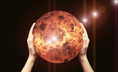 Two female hands hold a red-hot globe on a black background.Elements of this image are provided by NASA. The concept of global warming.Copy space, sun glare.