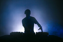 Black Silhouette Of A Male Disc Jockey Playing Music With A Mixer.