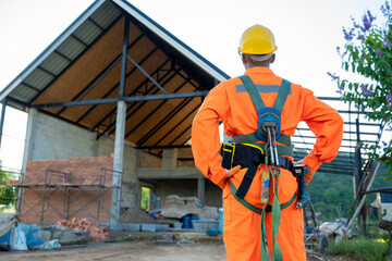 Electrical engineers wearing safety harness and safety line standing at construction site.