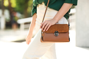 Young woman with stylish leather bag outdoors on summer day, closeup