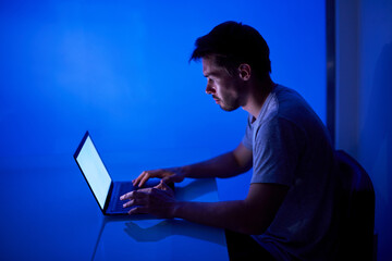 young guy programmer write software code for game or antivirus. photography for ad it technology