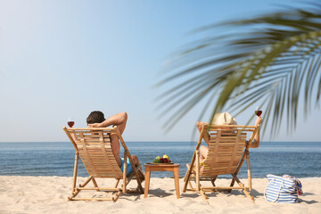 Canvas Print - Couple with wine on sunny beach at resort