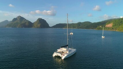 Wall Mural - Aerial drone view of sailing yacht anchored in the bay with clear and turquoise water on the sunset. Sailing yacht in the tropical lagoon. Tropical landscape. El Nido, Palawan island, Philippines.