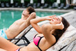 © LIGHTFIELD STUDIOS - selective focus of attractive girl touching sunglasses while lying on sunbed near man
