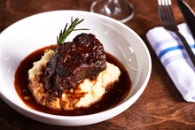 Braised Short Ribs And Mashed Potatoes In White Dish