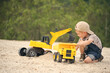 © Jacek - Child, little boy have fun with toy excavator and dumper in the sand. Carefree childhood.