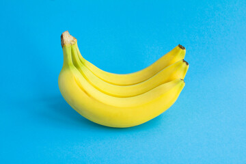 Wall Mural - Yellow bananas on the blue background. Closeup. Fruit background.