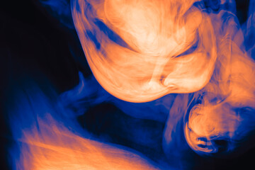 Wall Mural - clouds of colored flowing smoke on a dark background.