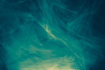 Wall Mural - clouds of colored flowing smoke on a dark background.