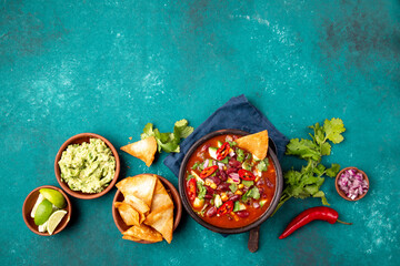 Wall Mural - Mexican food concept background with chile black bean soup, guacamole and nachos totopos. Top view