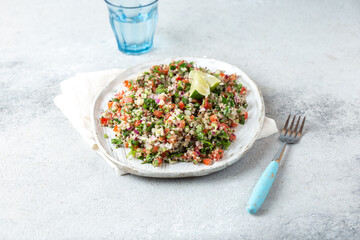 Quinoa Quinua salad with tomatoes and herbs in white bowl