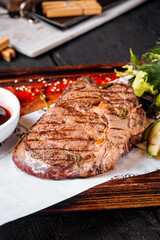 Wall Mural - Grilled juicy steak sauce salad on wooden board