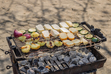 Vegeterian barbecue party with grill vegetables, mushrooms, onions, cheese, smoke coming from the charcoal