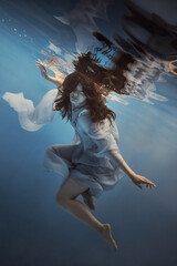 Wall Mural -   Portrait of a girl in a blue dress under water      