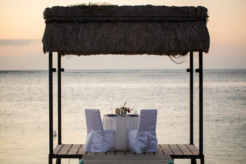 Wall Mural - Romantic dinner setting on the beach at sunset