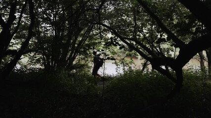 Wall Mural - Man walking through forest beside a river