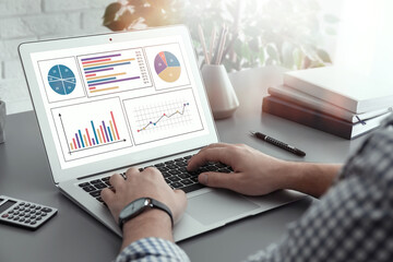 Man working with laptop at table, closeup. Business analytics