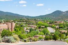 Cityscape View In Santa Fe, New Mexico Mountains Of Road Street Through Community Neighborhood With Green Plants Summer And Adobe Traditional Houses