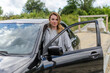 © Cliff - Young charming girl driving a black car