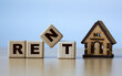 © Zhanna - RENT word on cubes on a light background with a wooden house
