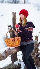 Wall Mural - The beautiful blonde girl in red hat in the forest. Girl in winter. White snow. Little Red Riding Hood