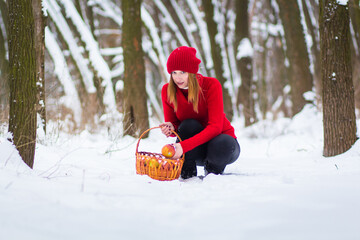 Wall Mural - The beautiful blonde girl in red hat in the forest. Girl in winter. White snow. Little Red Riding Hood. 