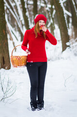 Wall Mural - The beautiful blonde girl in red hat in the forest. Girl in winter. White snow. Little Red Riding Hood. 