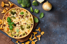 Homemade lorraine quiche or pie with chicken, broccoli and chanterelles on a blue background. Tart with meat and mushrooms. Top view. Copy space