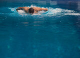 Fototapeta Łazienka - Male swimmer at the swimming pool. Underwater photo. Male swimmer.